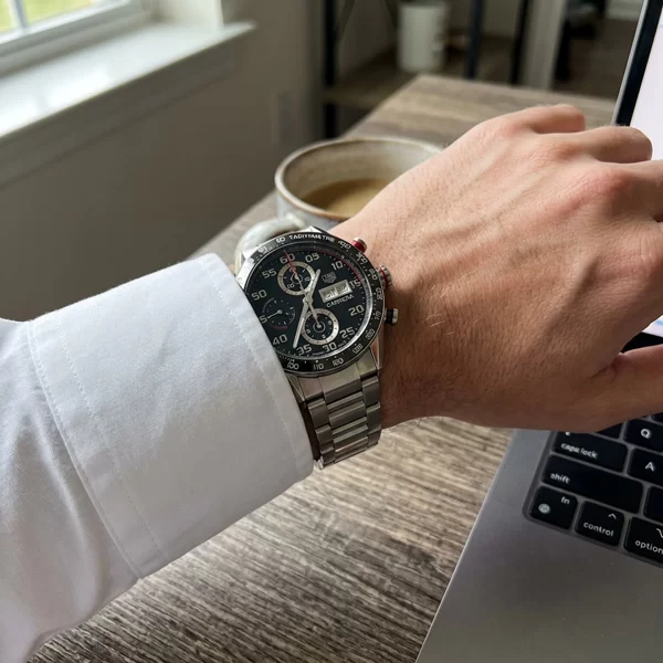 TAG Heuer Carrera Chronograph on a wrist with white business casual shirt visible in natural window light from the side