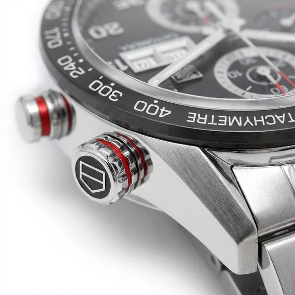 Close-up of TAG Heuer Carrera stainless steel crown and two chronograph pushers on the right side of the case with brushed and polished surface transitions visible