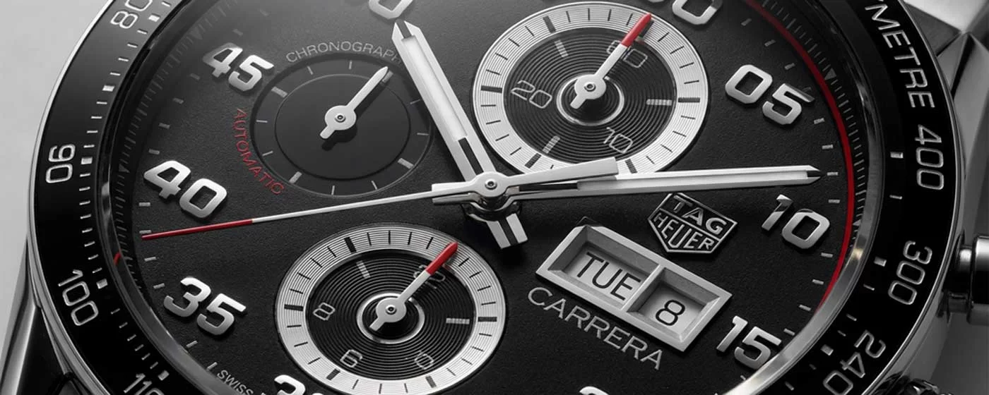 Overhead macro shot of TAG Heuer Carrera black opaline dial showing three recessed sub-dials rhodium-plated hands with Super-LumiNova and red chronograph seconds hand